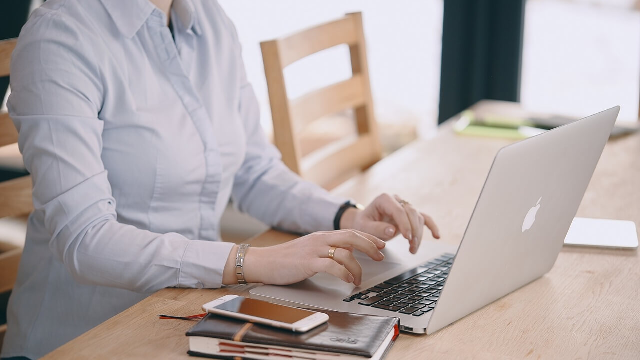 Frau tippt auf einem Apple Notebook